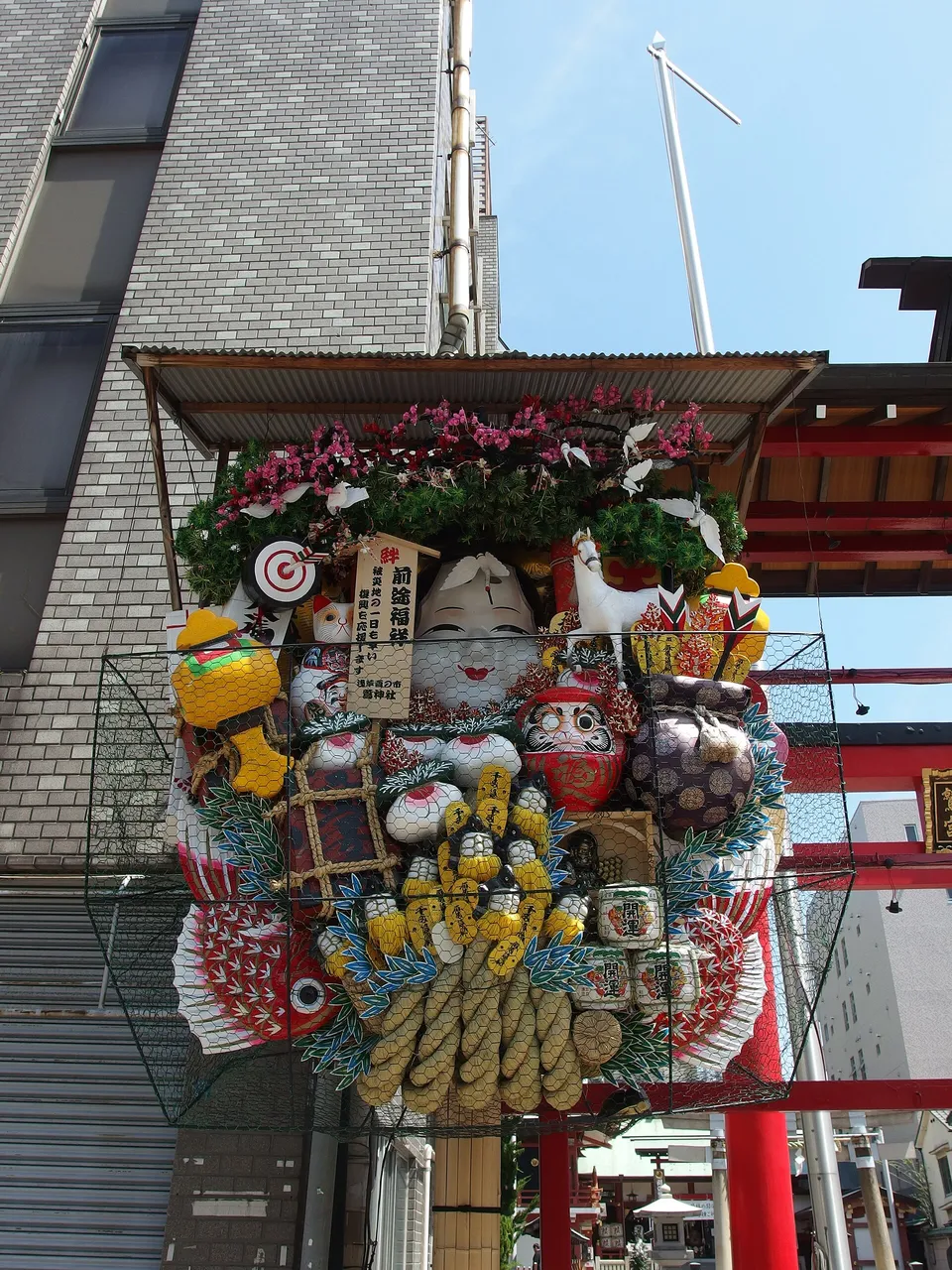Okame on a giant kumade at Ōtori Shrine